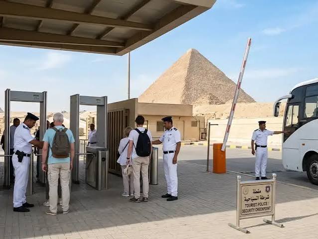 Tourists walking through the Iza Pyramids security entrance before entering.