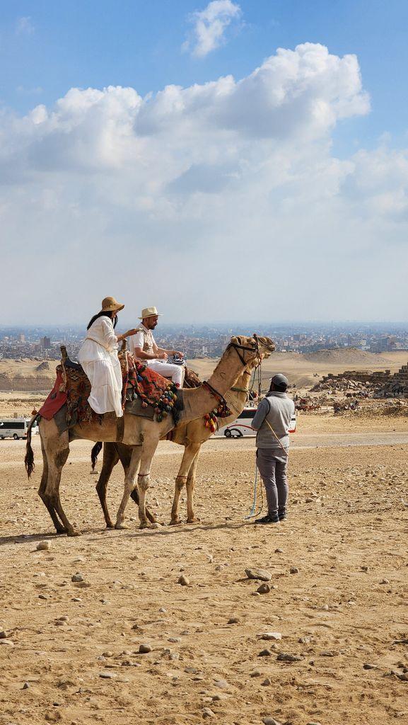 Tourists on camels with a guide in the Egyptian desert near Cairo.